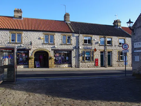 Bridge Street, Helmsley, with shops along the cobbled pavement