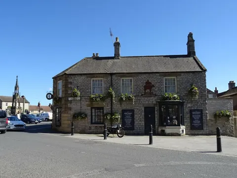A shop on Market Place, Helmsley, with the market cross behind