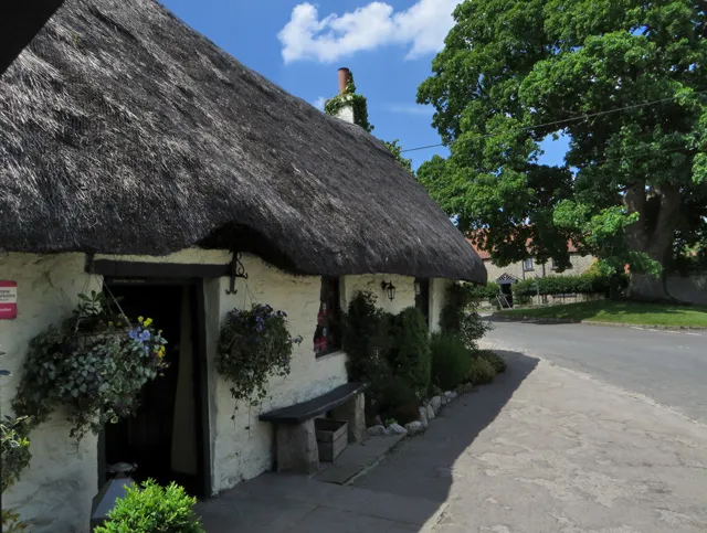 The Star Inn at Harome, a stone-built village pub with hanging baskets